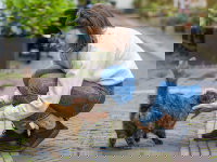 Une femme caresse un chat roux et noir dans la rue